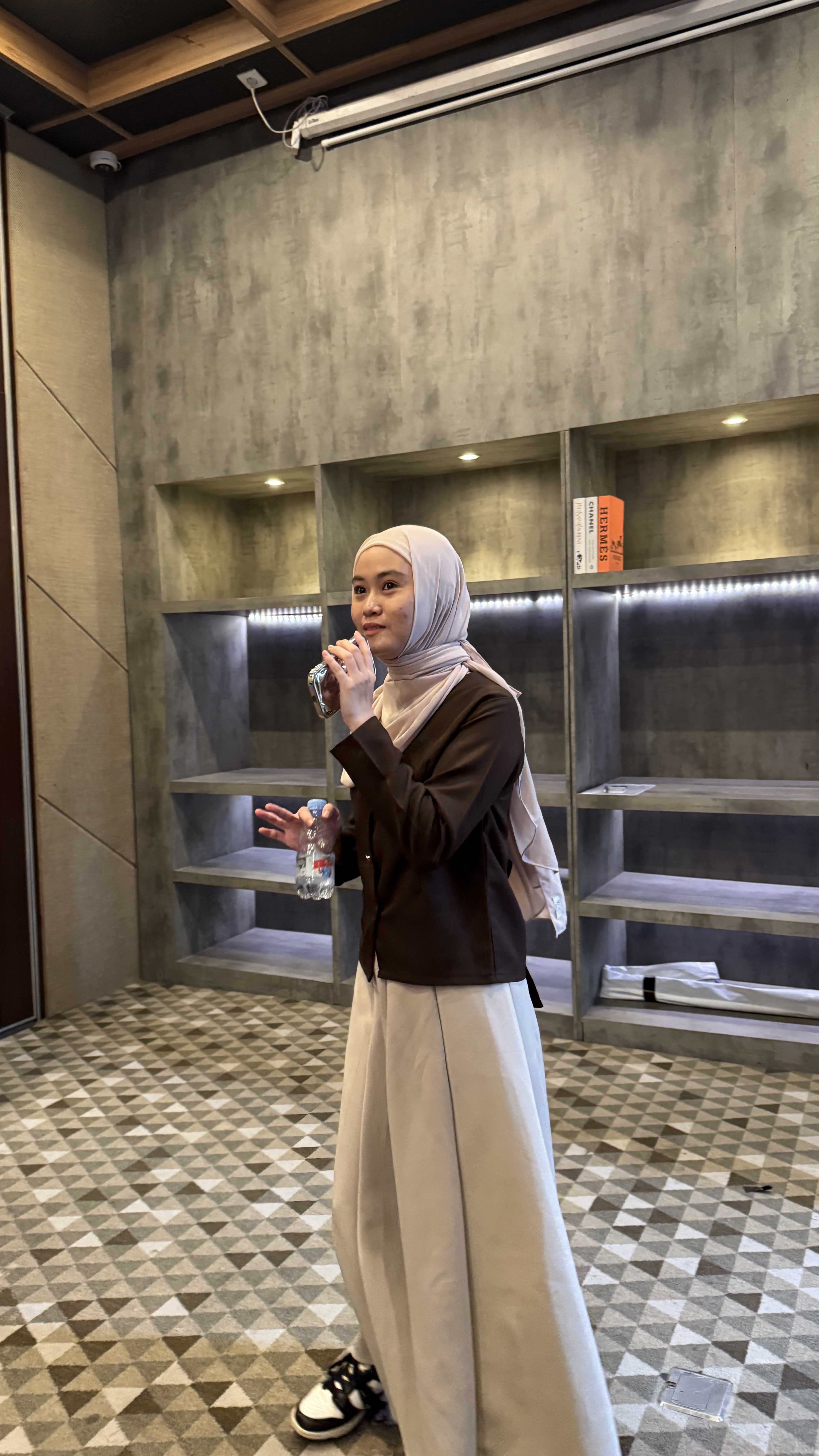 Reina at event venue holding microphone